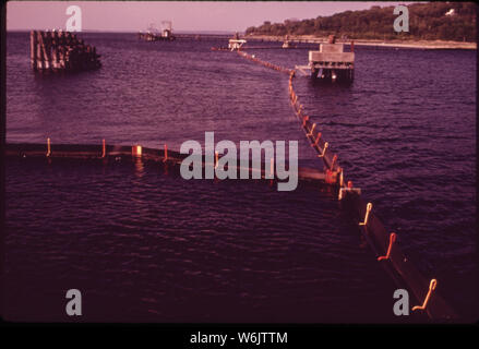 PART OF BOOM SYSTEM OF THE NORTH EAST PETROLEUM TANKER TERMINAL AT TIVERTON. THE LARGEST SUCH TERMINAL IN THE NORTHEAST, IT IS ALSO THE ONLY ONE THAT SURROUNDS EACH SHIP WITH AN OIL-CONTAINING BOOM Stock Photo