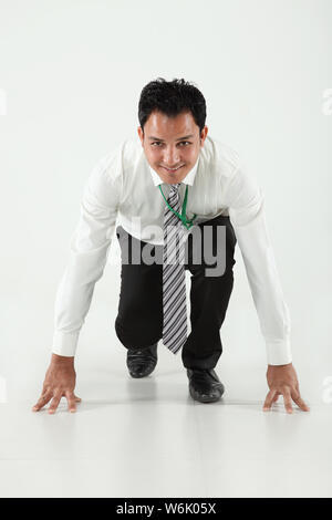 Businessman in race start position Stock Photo