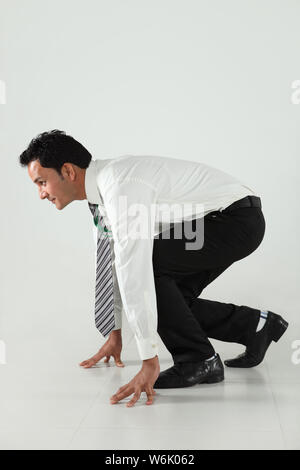 Businessman in race start position Stock Photo