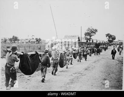 Photograph of American Prisoners Using Improvised Litters to Carry Comrades, 05/1942; Scope and content:  Original caption: This picture, captured from the Japanese, shows American prisoners using improvised litters to carry those of their comrades who, from the lack of food or water on the march from Bataan, fell along the road. Philippines, May 1942. General notes:  According to Colonel Melvin H. Rosen (U.S. Army Retired), this image is not a photograph taken during the Bataan Death March, but rather a photograph of a burial detail at Camp O'Donnell, the terminus of the Death March.  Mr. Ros Stock Photo