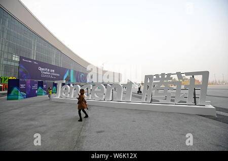 --FILE--A pedestrian walks past a logo of Tencent during an exhibition in Chengdu city, southwest China's Sichuan province, 8 November 2017.   Tencent Stock Photo