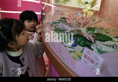 Children enjoy the hand-crafted pop-up 3D paper artworks created by Polish artist and illustrator Bozena Rydlewska on display during the 'New Bot-any' Stock Photo