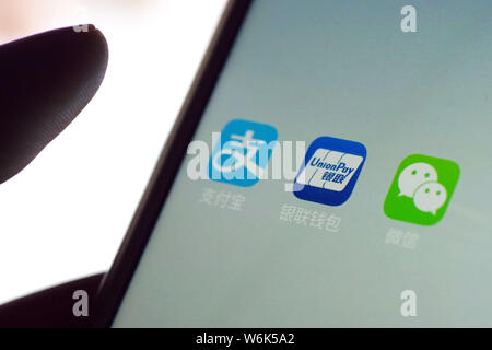 --FILE--A Chinese mobile phone user shows the icons of the mobile apps (from left) Alipay, the online payment service of Alibaba's Ant Financial, mobi Stock Photo