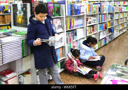 --FILE--Chinese children read books at a bookstore in Beijing, China, 30 January 2018.   Chinese children are not spending enough time reading, which Stock Photo