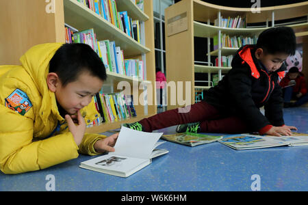 --FILE--Chinese children read books at a bookstore in Ji'nan city, east China's Shandong province, 30 January 2018.   Chinese children are not spendin Stock Photo