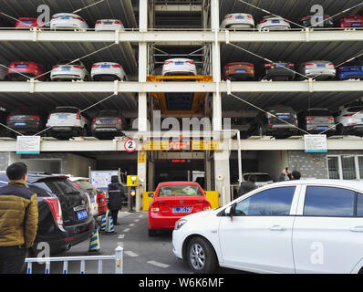 Chinese drivers queue up to park their cars in an automated stacked parking lot in the Peking University Shougang Hospital in Beijing, China, 8 Februa Stock Photo