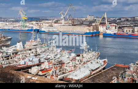 Cargo ships and Russian Navy warships moored in Yuzhnaya Bay, one of the harbour bays in Sevastopol, Crimea Stock Photo