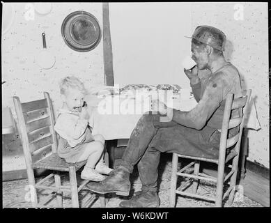 Rufus Sergent, miner, and his son have a bit to eat after work. P V & K Coal Company, Clover Gap Mine, Lejunior, Harlan County, Kentucky. Stock Photo