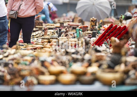 (Selective focus) Close-up view of some souvenirs (singing bowls, hand created statues and Rudraksha necklace) on a street market stall in Kathmandu. Stock Photo