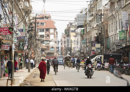 A Buddhist monk is walking through the polluted streets of Kathmandu, Nepal. Stock Photo