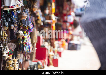 (Selective focus) Close-up view of some souvenirs (singing bowls, hand created statues and Rudraksha necklace) on a street market stall in Kathmandu. Stock Photo