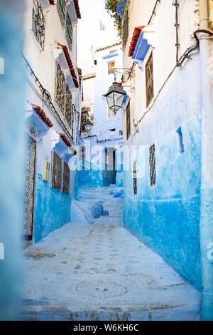 Stunning view of a narrow alleyway with the striking, blue-washed buildings. Chefchaouen, or Chaouen, is a city in the Rif Mountains of Morocco. Stock Photo