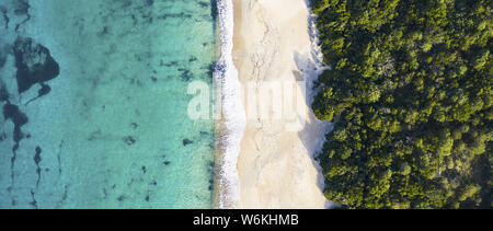 View from above, stunning aerial view of an amazing wild beach bathed by a transparent and turquoise sea. Sardinia, Italy. Stock Photo