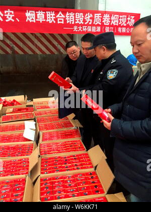 Chinese police officers check 2,333 cartons of counterfeit Zhonghua brand cigarettes seized during a winter operation in Zhenjiang city, east China's Stock Photo