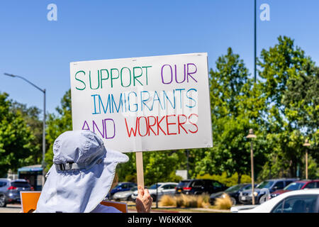 July 26, 2019 Palo Alto / CA / USA - Protester holding a sign with the message 'Support our immigrants and workers' Stock Photo