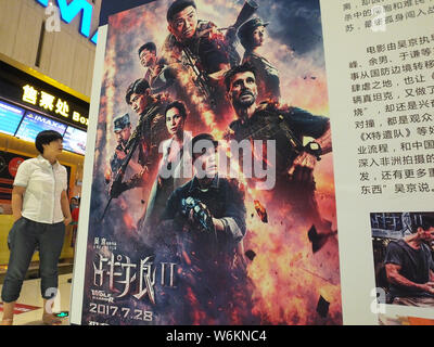 --FILE--A Chinese filmgoer walks past a poster of the Chinese action movie "Wolf Warriors 2" directed by Wu Jing at a cinema in Yichang city, central Stock Photo