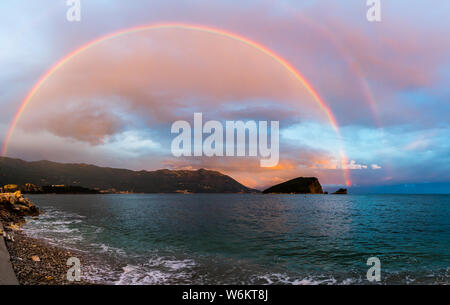 Montenegro, XXL nature landscape panorama of beach and coast of budva under spectacular colorful rainbow natural spectacle at sunset after rain and th Stock Photo