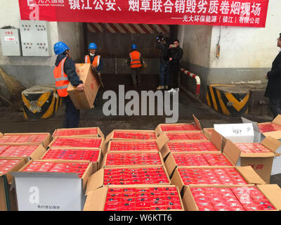 Chinese police officers check 2,333 cartons of counterfeit Zhonghua brand cigarettes seized during a winter operation in Zhenjiang city, east China's Stock Photo