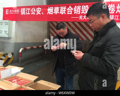 Chinese police officers check 2,333 cartons of counterfeit Zhonghua brand cigarettes seized during a winter operation in Zhenjiang city, east China's Stock Photo