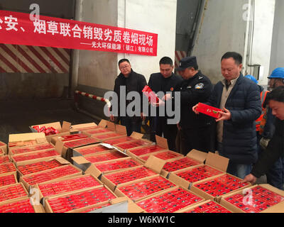 Chinese police officers check 2,333 cartons of counterfeit Zhonghua brand cigarettes seized during a winter operation in Zhenjiang city, east China's Stock Photo