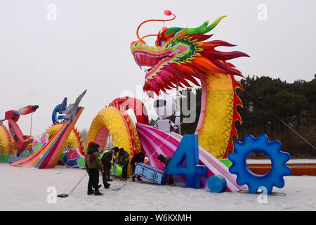 Pedestrians walk past a colorful lantern on display ahead of the 2018 Shenyang International Colorful Lantern Cultural Festival in Shenyang city, nort Stock Photo