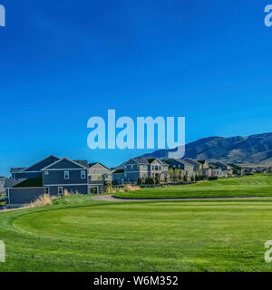 Square Residential area on a valley with view of mountain under blue sky and bright sun Stock Photo