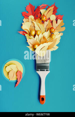 dav softTop view on flat lay with brush loaded with paint made from paper Autumn leaves. Concept home renovation background in blue, yellow, orange an Stock Photo