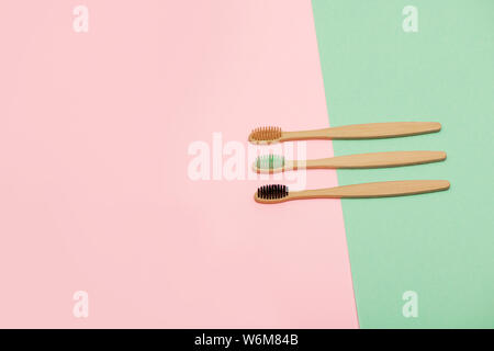 Set of bamboo toothbrushes on pink and turquoise background. Top view. Flat lay. Stock Photo
