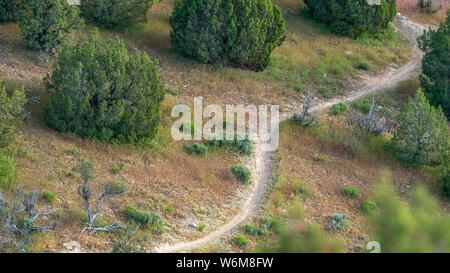 Panorama frame Narrow hiking trail curving through the grassy terrain of a mountain Stock Photo