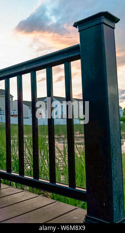 Vertical frame Bridge over a pond with multi storey homes and cloudy sky in the background Stock Photo