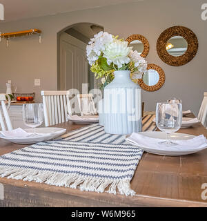Square Dining room interior with brown wooden table and white wooden chairs Stock Photo