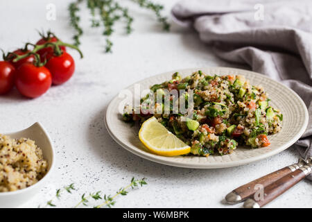 Quinoa salad with fresh tomatoes, cucumbers and salad leaves. Superfood and healthy eating concept Stock Photo