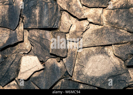 textured wall covered by embedded grey  slate stone Stock Photo