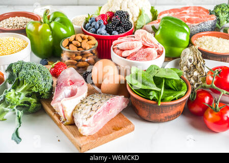 Pescetarian diet plan ingredients, healthy balanced grocery food, fresh fruit, berries, fish and shellfish clams, white marble background copy space Stock Photo