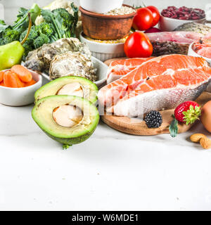 Pescetarian diet plan ingredients, healthy balanced grocery food, fresh fruit, berries, fish and shellfish clams, white marble background copy space Stock Photo