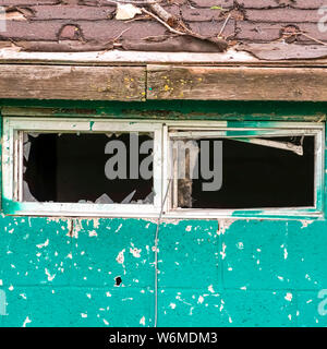 Square frame Close up of the small window with broken glass of an old and weathered shed Stock Photo