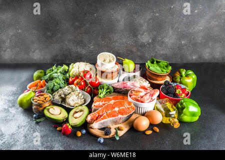 Pescetarian diet plan ingredients, healthy balanced grocery food, fresh fruit, berries, fish and shellfish clams, black stone concrete background copy Stock Photo