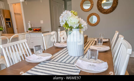 Panorama Table runner flowers glasses napkins and plates arranged on top of dining table Stock Photo
