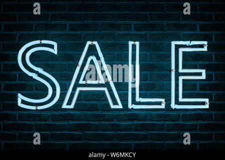 3d illustration: Advertising neon sign with the inscription 'sale' of blue letters on the background of a red brick wall. Stock Photo