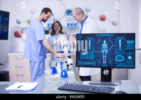 Team of researchers working and shwoing information on monitor display. Body x-ray. Stock Photo