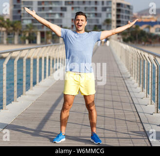Young athletic man dressed in sportswear going to practice workout outdoors Stock Photo