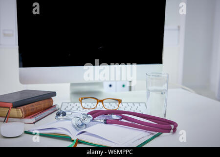 Stethoscope lying on a table on an open book. Stock Photo