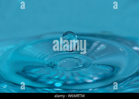 Texture, background with falling water drops and waves with blue water Stock Photo