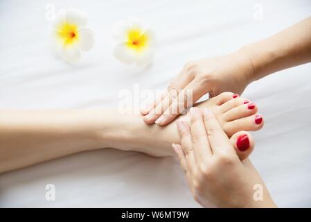 Woman receiving foot massage service from masseuse close up at hand and foot - relax in foot massage therapy service concept Stock Photo