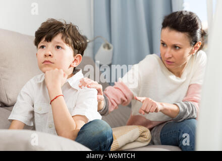 Portrait Of Upset Teen Boy In Sportswear Scolded By Mother At