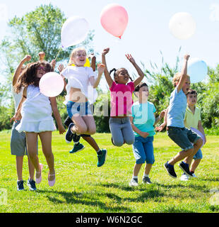 Friendly kids jumping together on the street Stock Photo - Alamy
