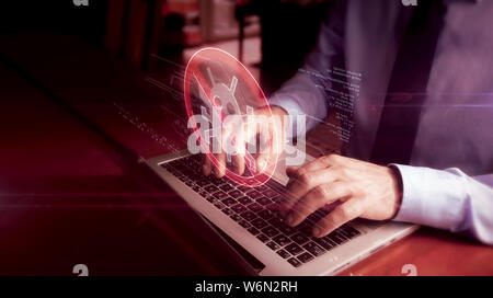 Man typing on laptop with antivirus hologram screen over keyboard. Computer protection, cyber security and internet safety concept. Stock Photo