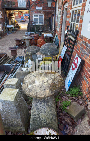 Staddle stones and vintage stone garden ornaments on display in the yard of an antique shop in Hungerford, a historic market town in Berkshire, UK Stock Photo
