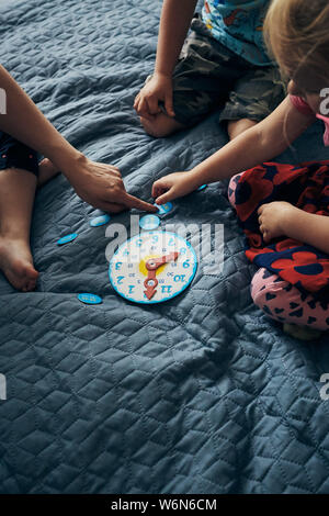 Kids learning how to tell time from clock and set the hands in the correct position. Teaching preschoolers tell time. Candid people, real moments, aut Stock Photo