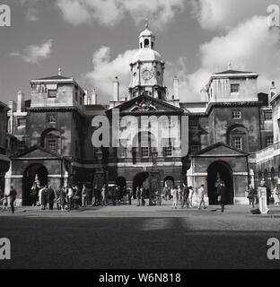 1960s, historical, people in Whitehall outside the historic building of Horse Guards, Westminster, London, England, UK. Built in the mid-18th century as a barracks for the Household Cavalry, it later became an important military headquarters. As the original entrance to the Palace of Westminster and St James Palance it is stll ceremonially defended by the Queen's Life Guard and it this which attracts the many visitors. Stock Photo